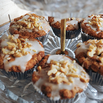 Glasetagere mit saftigen Muffins, glasiert und bestreut mit gehackten Walnüssen